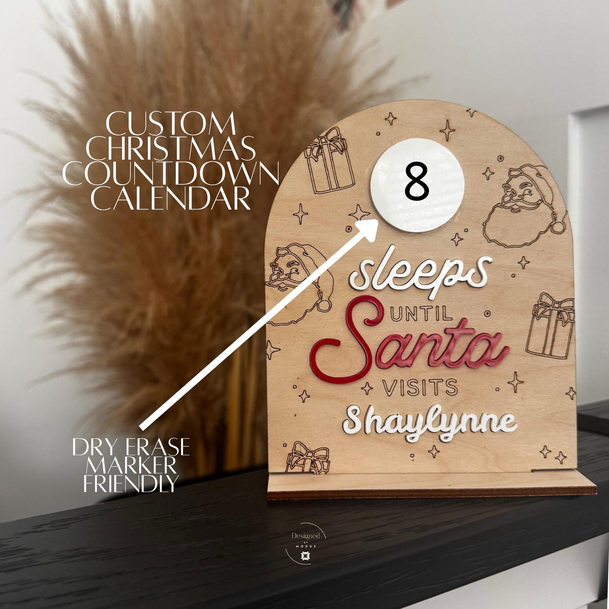 Custom “Sleeps Until Santa” countdown board made of engraved wood with Santa and gift details, personalized with child’s name on holiday background.