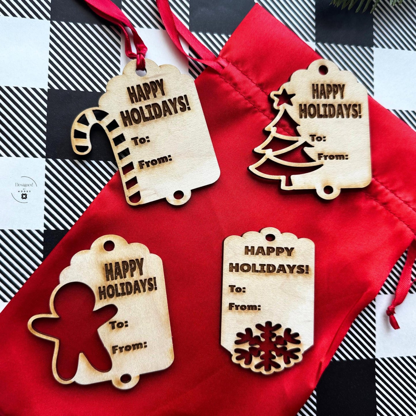 Full set of four engraved wooden gift tags — Candy Cane, Tree, Gingerbread, and Snowflake — displayed on red drawstring bag for Christmas gifts.