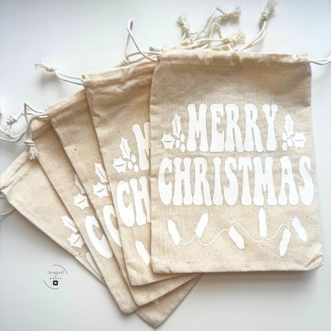 Five reusable linen “Merry Christmas” bags with white vinyl print and holly leaf design, ideal for slime kits, kids gifts, or holiday favors.