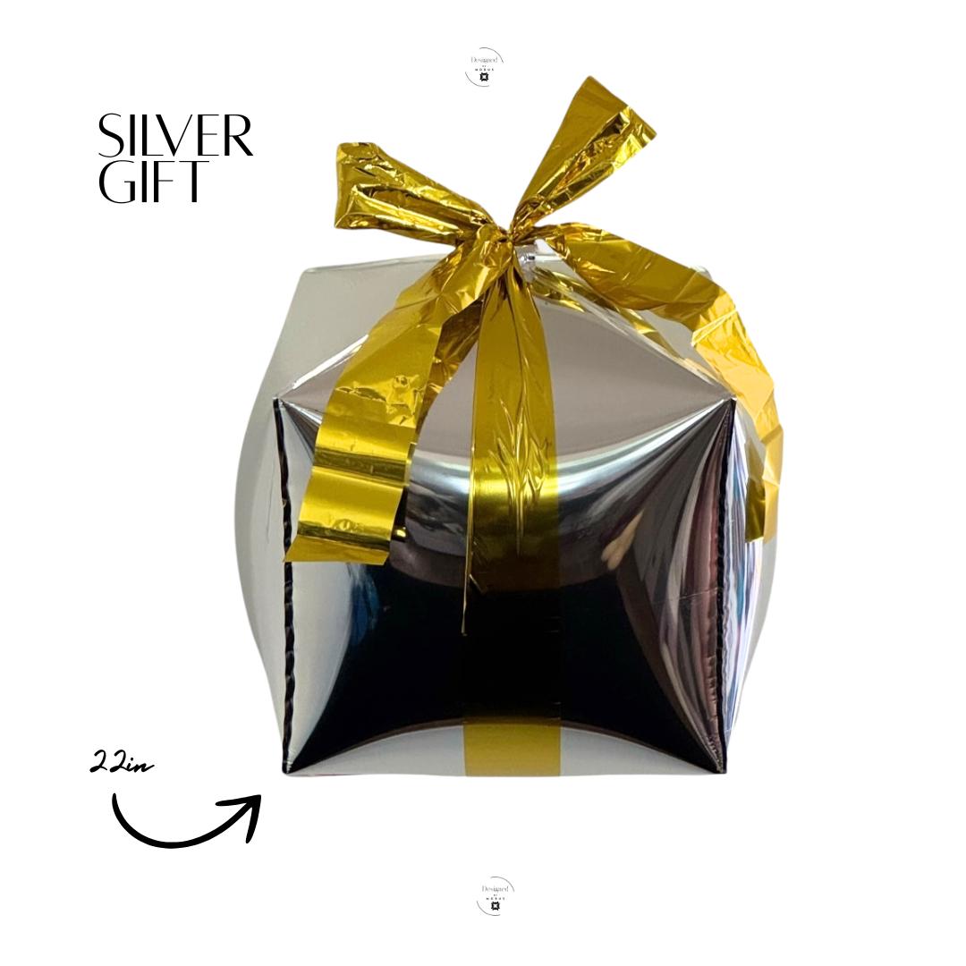 22-inch silver gift box mylar balloon with shiny gold bow, metallic holiday party decoration by Designed by Modus.