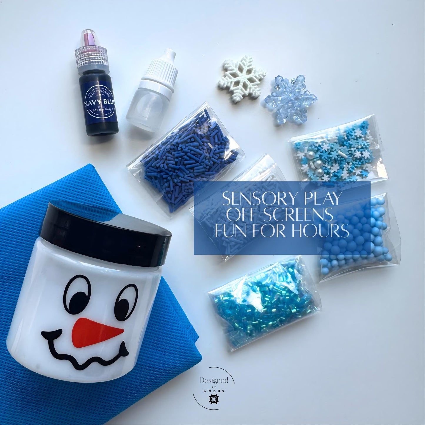 Flat lay of Snowflake Slime Kit items including snowman jar, blue sprinkles, snowflake charms, activator, dye, and blue foam beads with the caption “Sensory Play Off Screens Fun for Hours.”