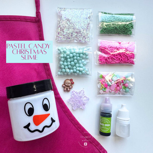 Pastel Candy Christmas Slime Kit with white slime in snowman jar, pink apron, and pastel holiday mix-ins labeled “Pastel Candy Christmas Slime.”