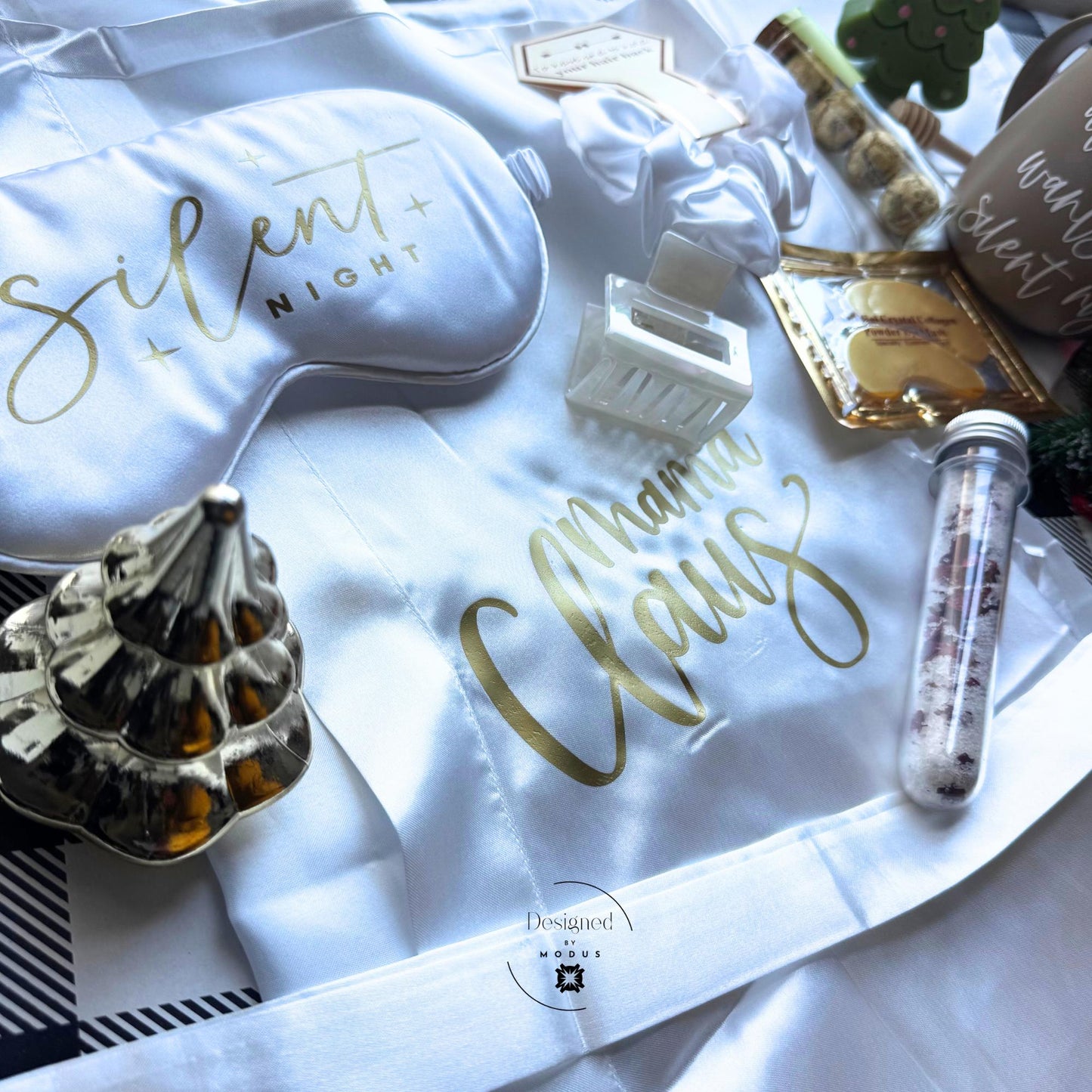 lat lay of Mama Claus Silent Night Christmas gift box with silk robe, mug, eye mask, and spa accessories.