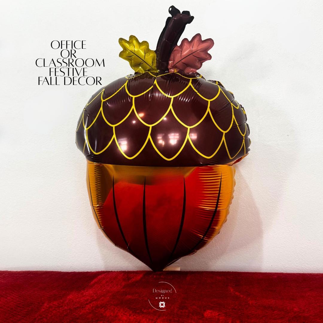 Brown and gold acorn balloon with leaf details used for festive classroom or office fall decoration.”