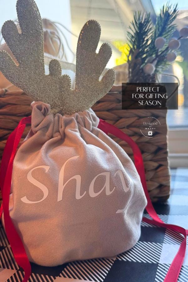 Golden reindeer velvet Christmas gift bag with red ribbon, personalized holiday packaging for gifting season.