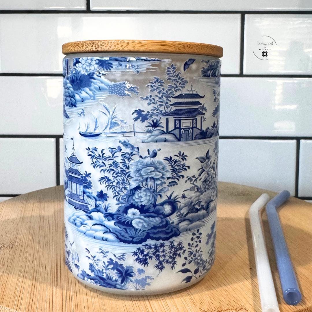 Side view showing scenic blue and white pattern on frosted glass with handle.