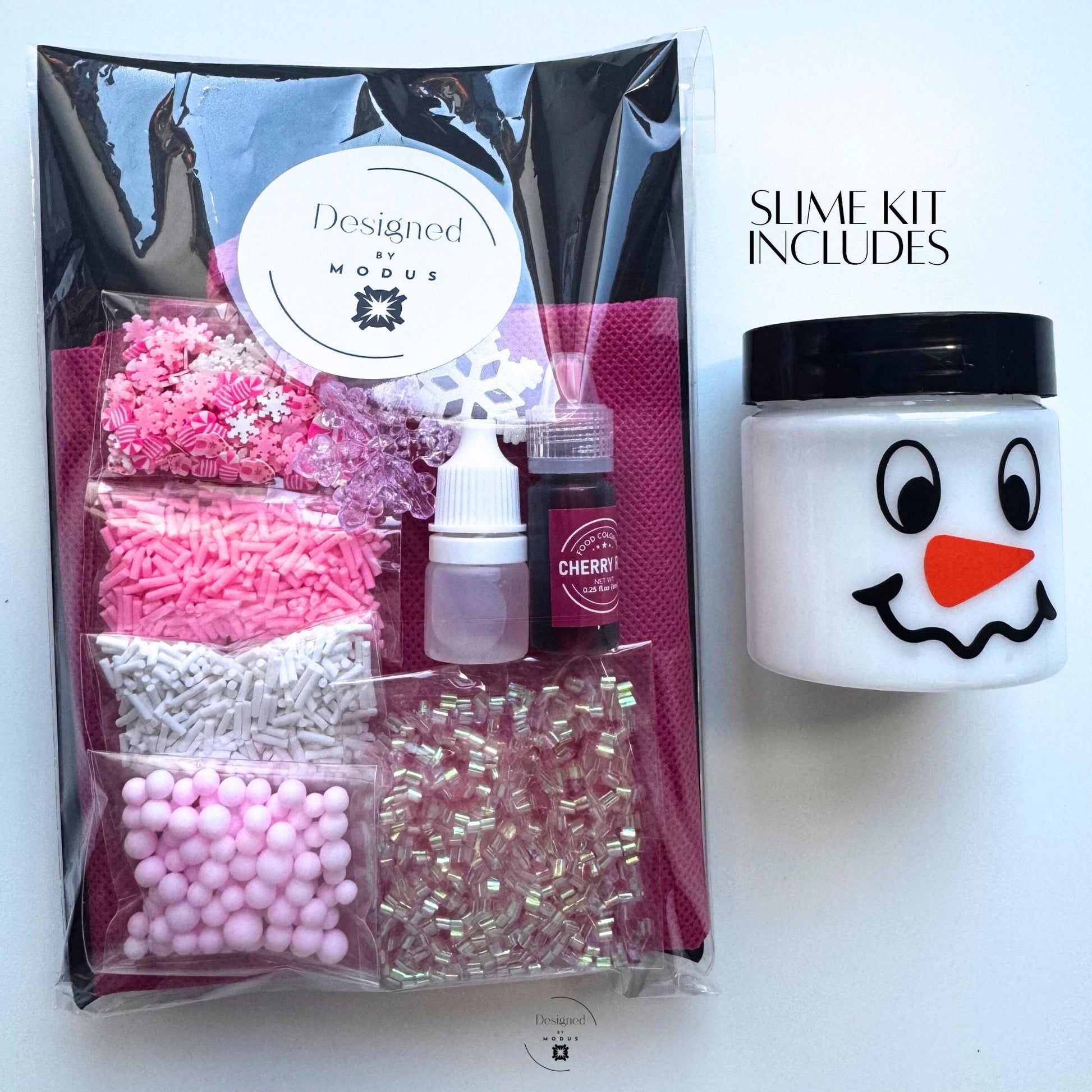 Packaged Pink Peppermint Slime Kit with Designed by Modus label, featuring pre-packed mix-ins, dye, activator, and snowman jar labeled “Slime Kit Includes.”