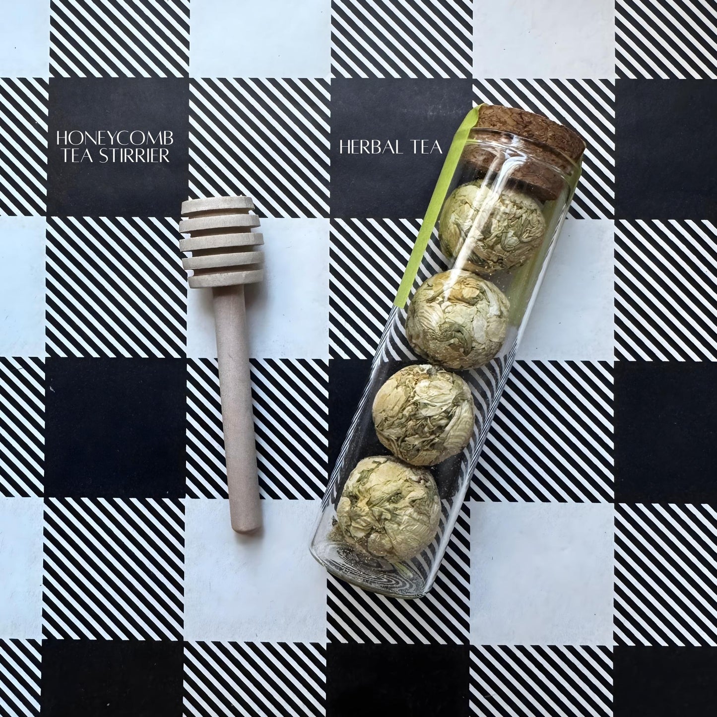 Wooden honeycomb tea stirrer with floral herbal tea in glass tube, labeled “Honeycomb Tea Stirrer & Herbal Tea.”