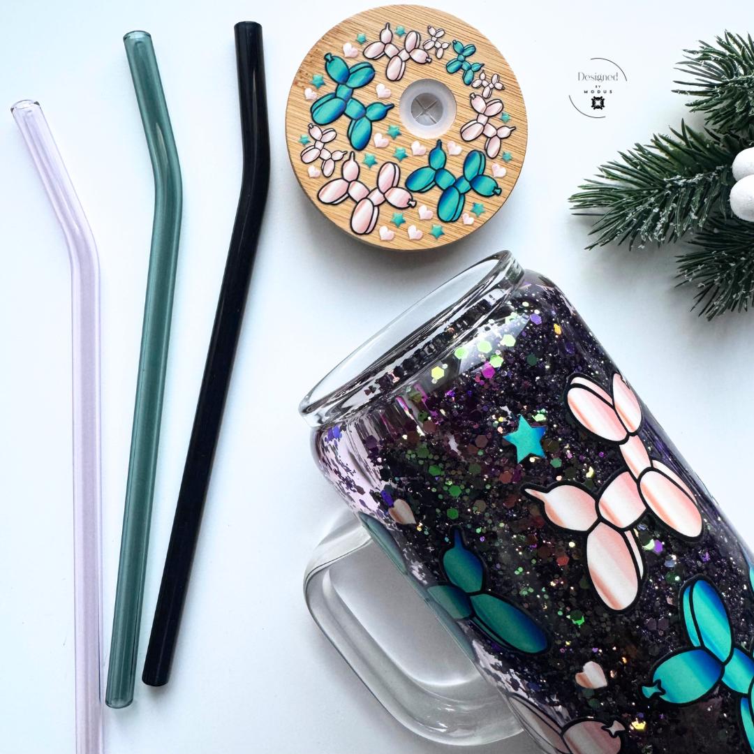 Balloon-dog glitter mug with bamboo lid and black-and-white bow on glass straws.