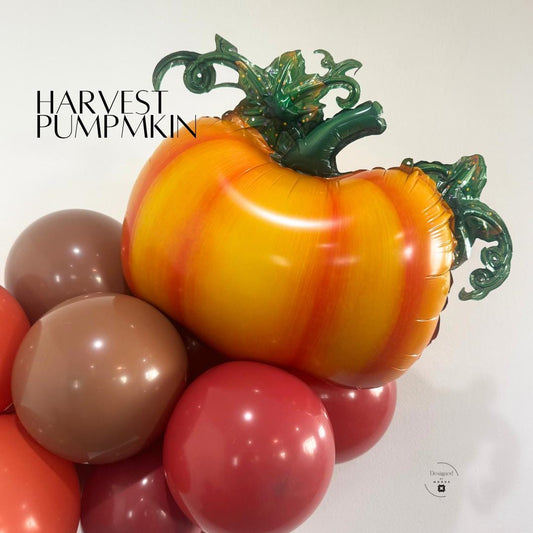 “Harvest pumpkin mylar balloon with green vine details surrounded by brown and orange balloons for fall decor.”