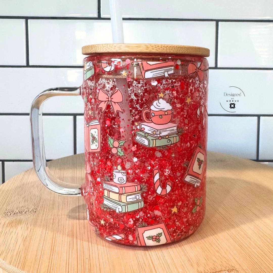 Side view of cozy book lover’s Christmas glass cup with floating glitter and cute illustrations.