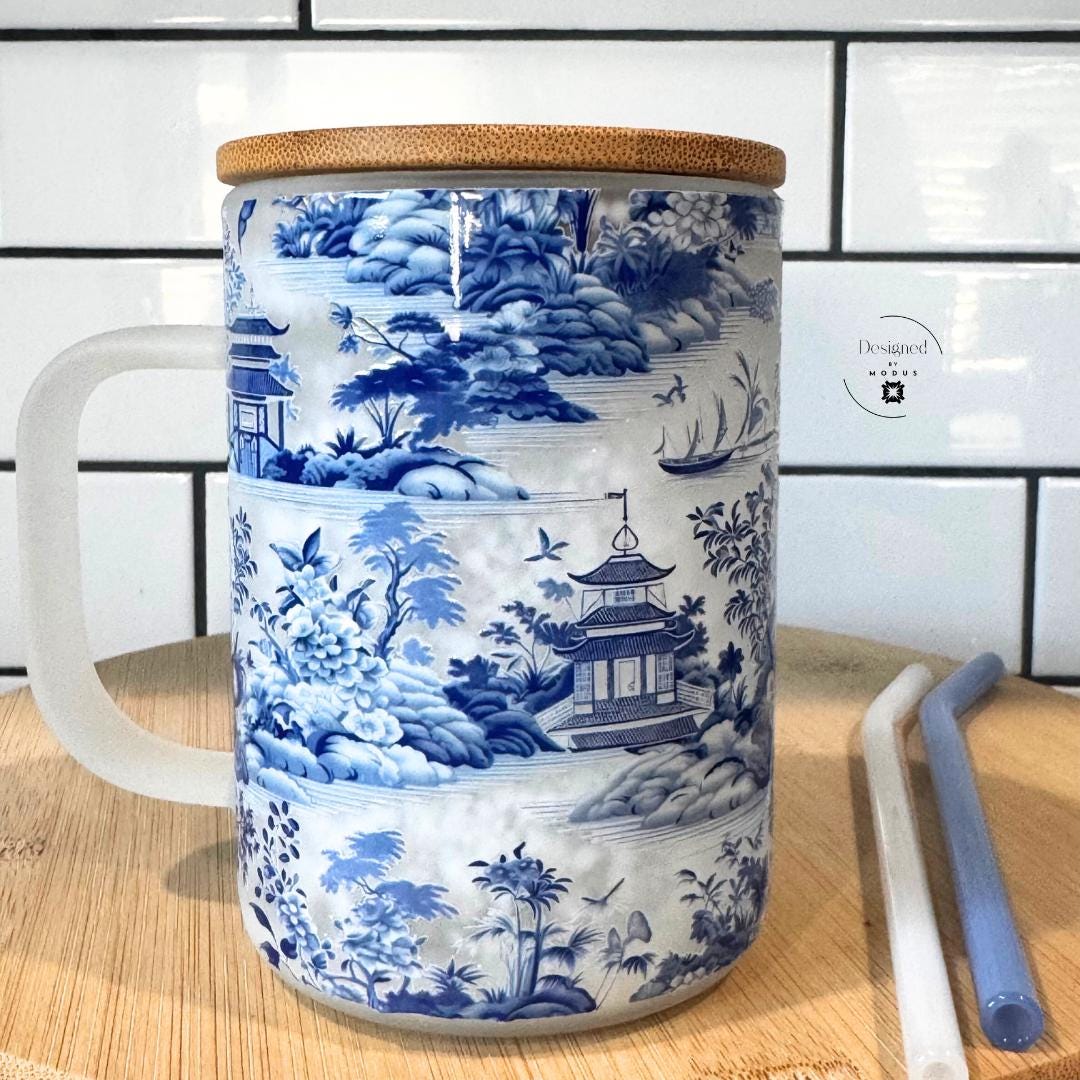 Front-facing view of blue and white snowglobe glass cup with handle.