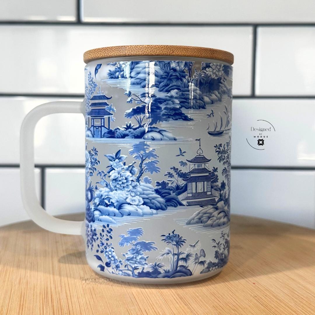 Front-facing view of blue and white snowglobe glass cup with handle.