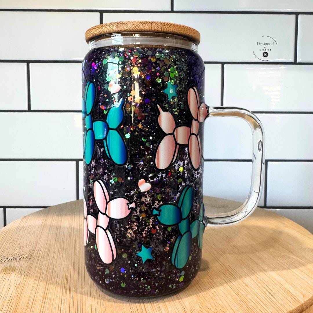 Front view of snowglobe-style mug with handle and sparkling glitter.