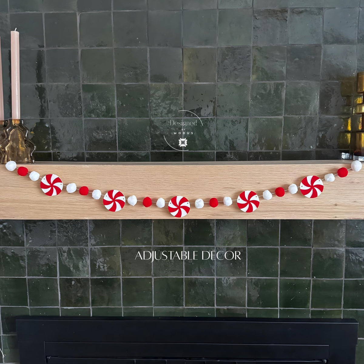 Red and white peppermint felt garland with felt balls hanging on a mantel.