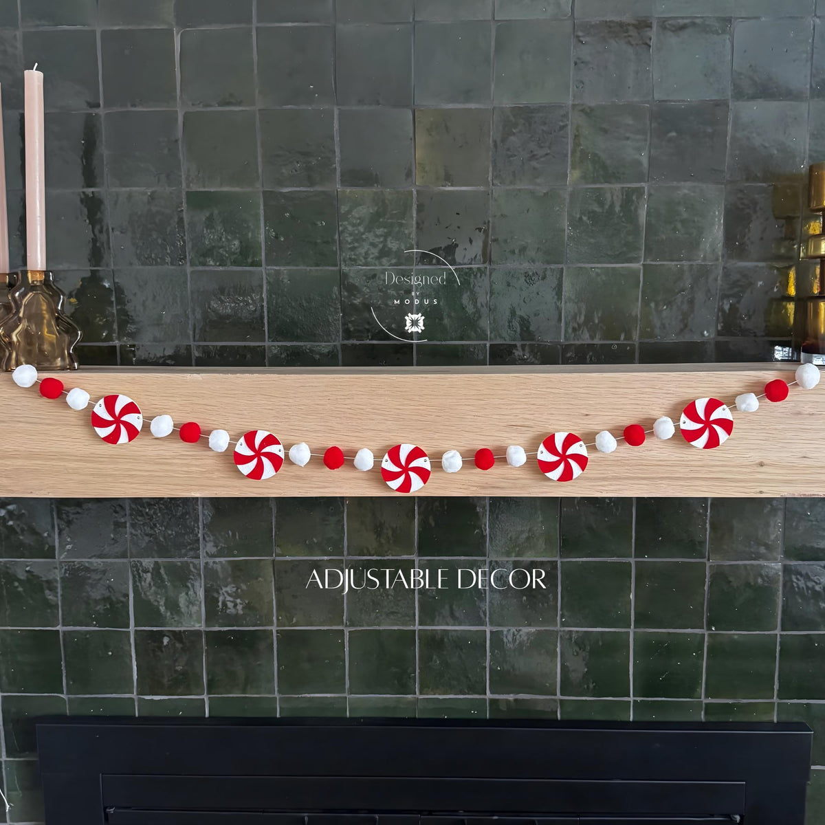 Red and white peppermint felt garland with felt balls hanging on a mantel.