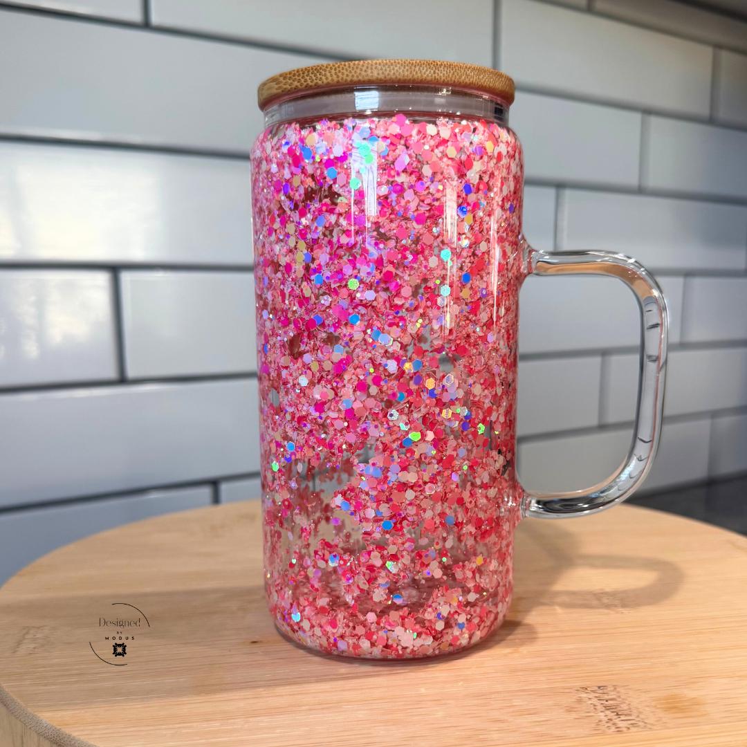 Pink glitter glass tumbler with handle on wooden stand