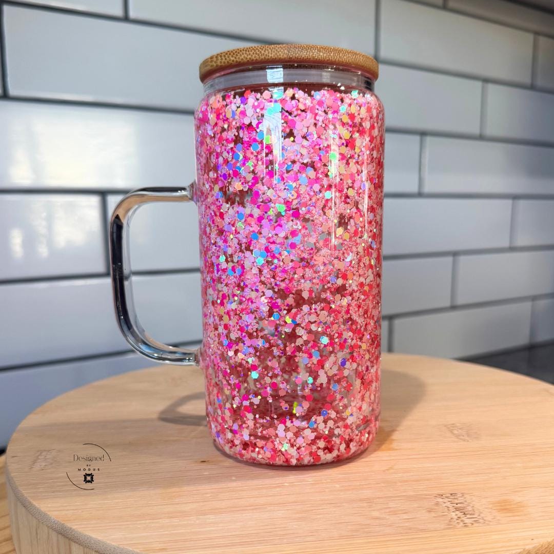 Close-up of pink glitter double wall glass mug with bamboo lid