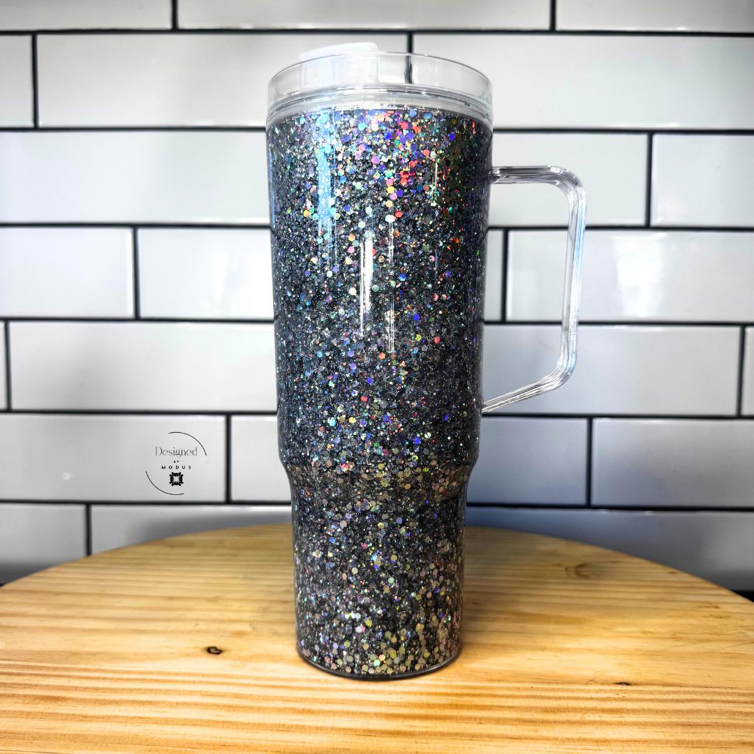 Silver chrome holographic glitter snow globe tumbler with handle on wooden table