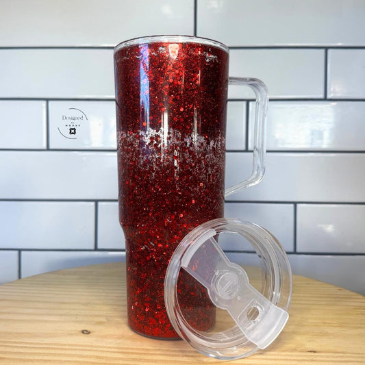 Red glitter tumbler with clear slide lid placed beside it