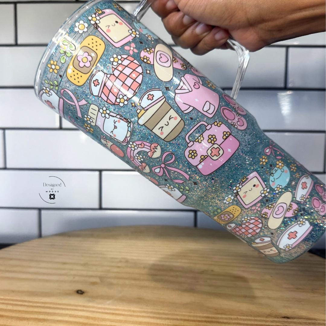 Hand holding glitter nurse tumbler showing full wraparound design.