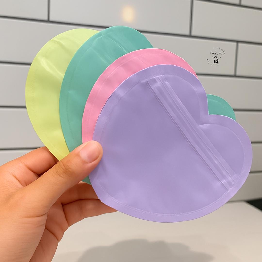 Hand holding pastel heart resealable bag showing scale