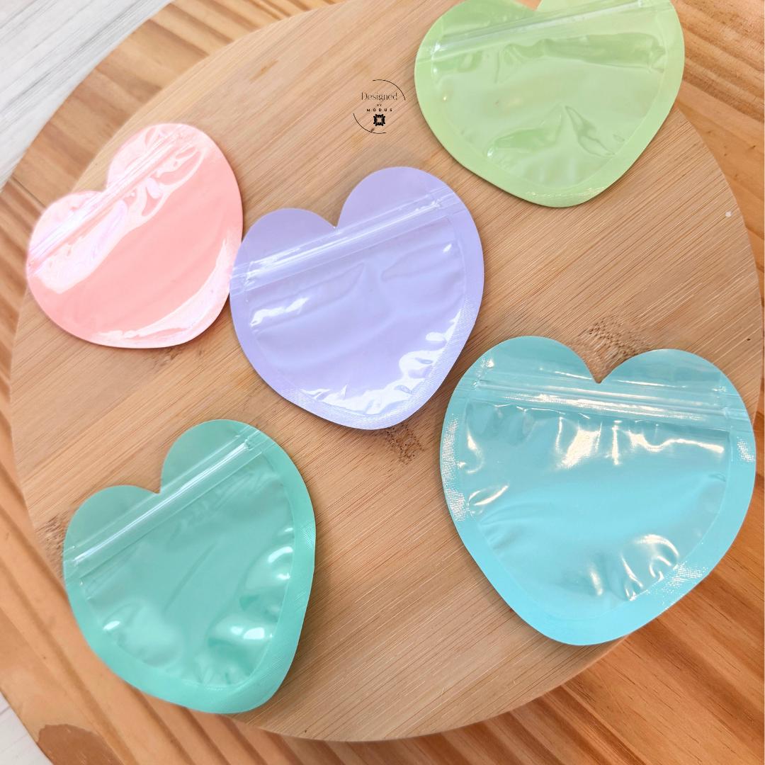 Heart shaped plastic bags arranged on round wooden board