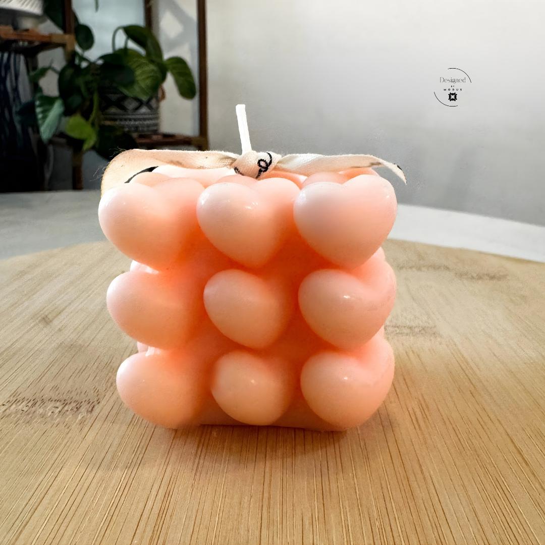 Heart cube candle with stacked heart design in soft pastel color
Close up of heart shaped cube candle decorative texture