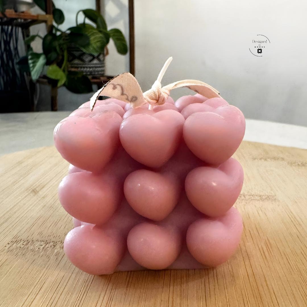 Heart cube candle with stacked heart design in soft pastel color
Close up of heart shaped cube candle decorative texture
