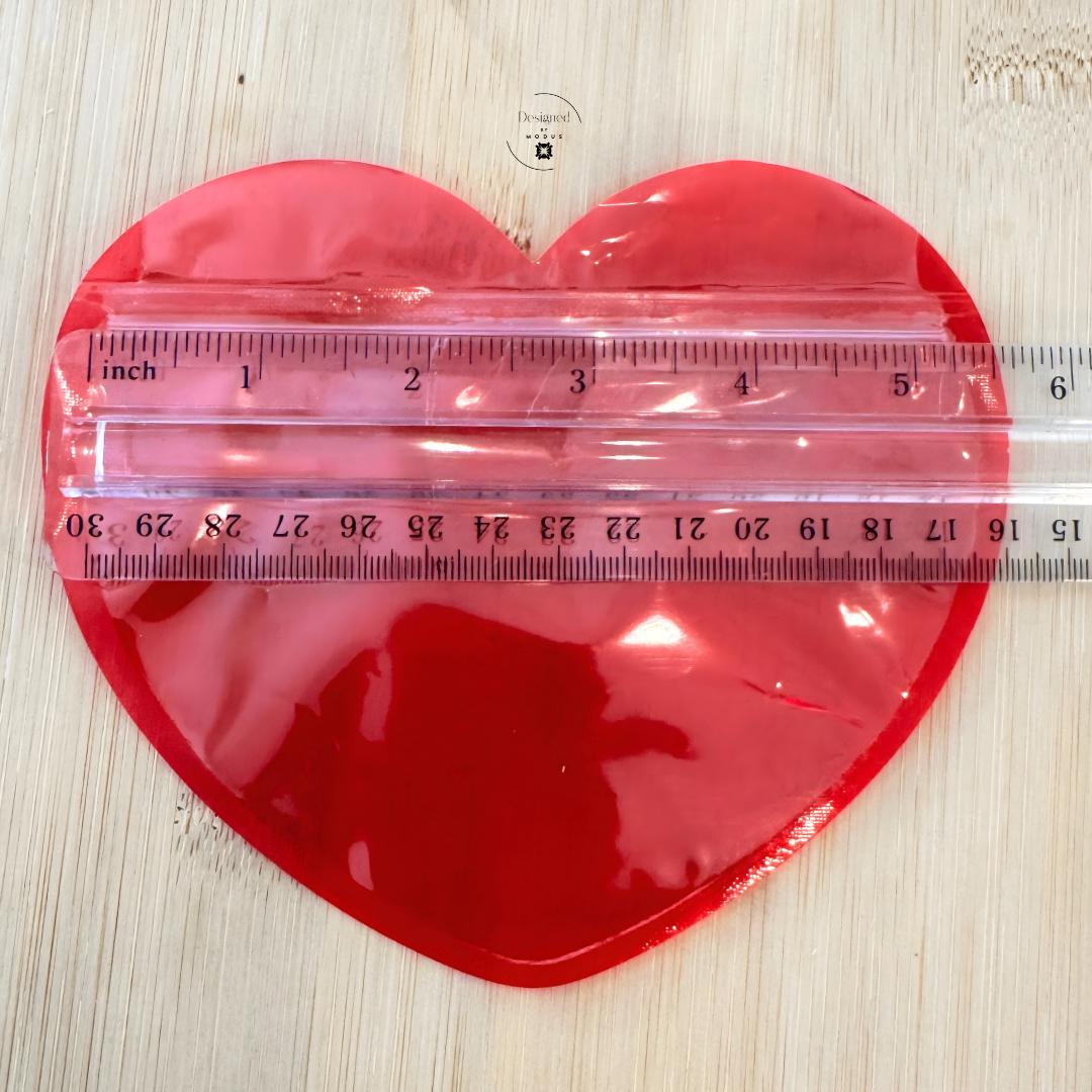 Red heart pouch showing scale with ruler