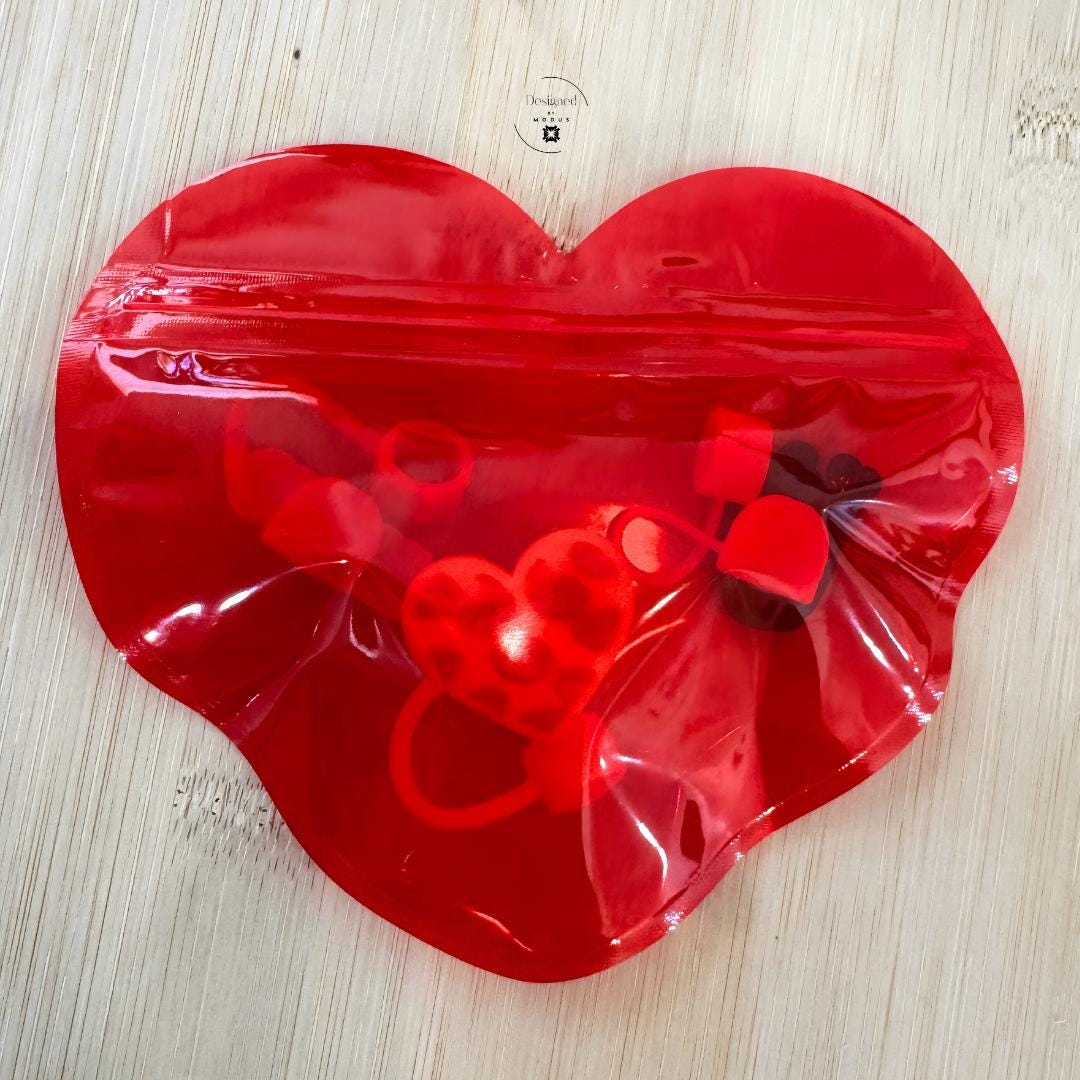 Heart shaped zip bag with small Valentine charms inside