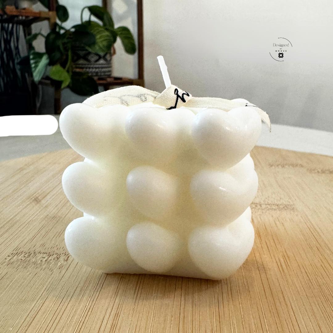Heart cube candle with stacked heart design in soft pastel color
Close up of heart shaped cube candle decorative texture