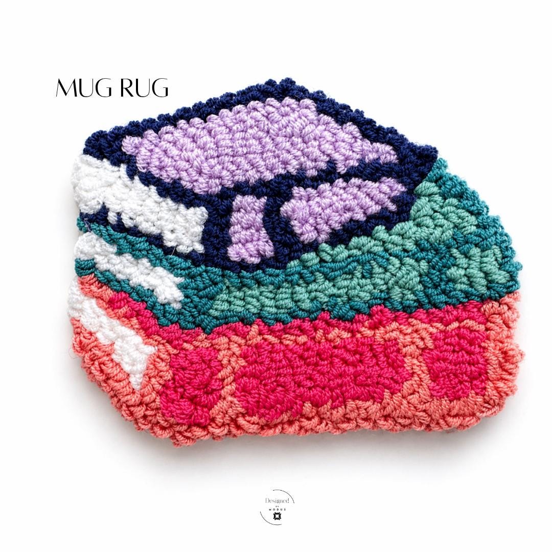 Punch Needle Coaster Handmade Artisan Craft Mug Rug Floral Design Purple Flowers Navy Blue Background Cotton Yarn Construction Plush Textured Surface Teal Coral Pink Border White Accents Coffee Table Styling Kitchen Counter Protection Tea