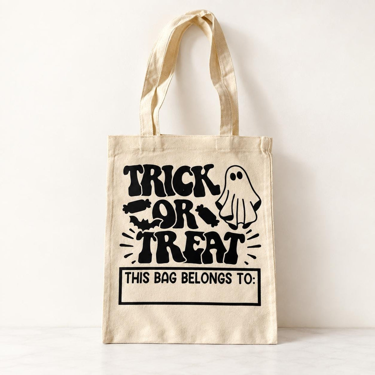 Halloween candy tote with trick or treating ghost design and personalized child’s name. Choose a black, natural or white cotton bag to create a custom trick or treat bag for Halloween night. Perfect for kids collecting candy, attending trunk or treat, Halloween parties, school celebrations and fall festivals. Personalized Halloween tote makes a cute spooky season gift.