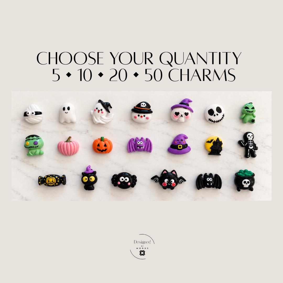 Assorted Halloween flatback charms displayed together featuring cute spooky characters in orange, purple, black, white, green and pink. Mystery Halloween charm assortment for slime supplies, decoden crafts, bow centers, scrapbook embellishments, handmade gifts, Halloween party activities and other DIY craft projects. Designs vary with each mystery charm mix.