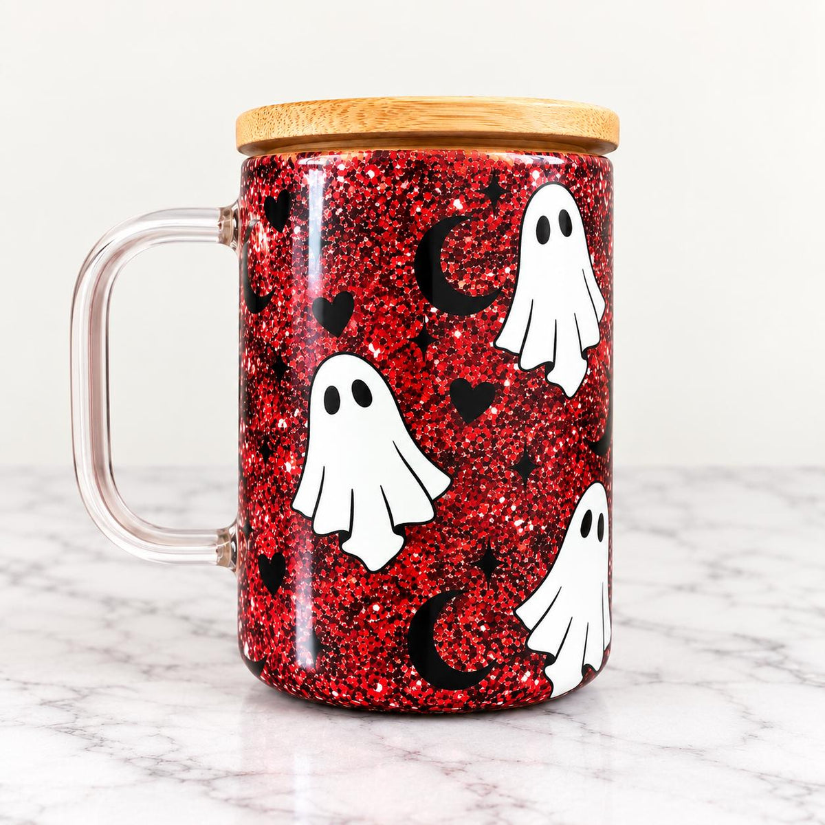Spooky ghost Halloween snow globe tumbler filled with red, black and silver glitter for a festive sparkling effect. The clear tumbler features a white ghost graphic with bold Halloween lettering and a bamboo style lid. Cute Halloween drinkware for spooky season, Halloween parties, fall celebrations, gifts and everyday seasonal drinks.