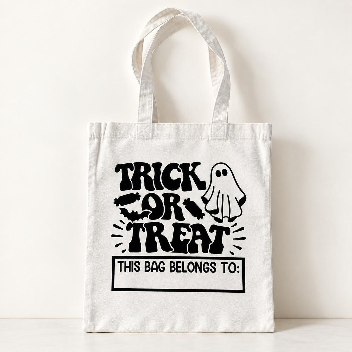 Personalized ghost trick or treat bag for kids featuring a custom name and playful Halloween design. This cotton Halloween tote is made for carrying candy and treats during trick or treating, trunk or treat events, costume parties and fall celebrations. Cute reusable Halloween candy bag for boys and girls and a fun custom Halloween gift for spooky season.