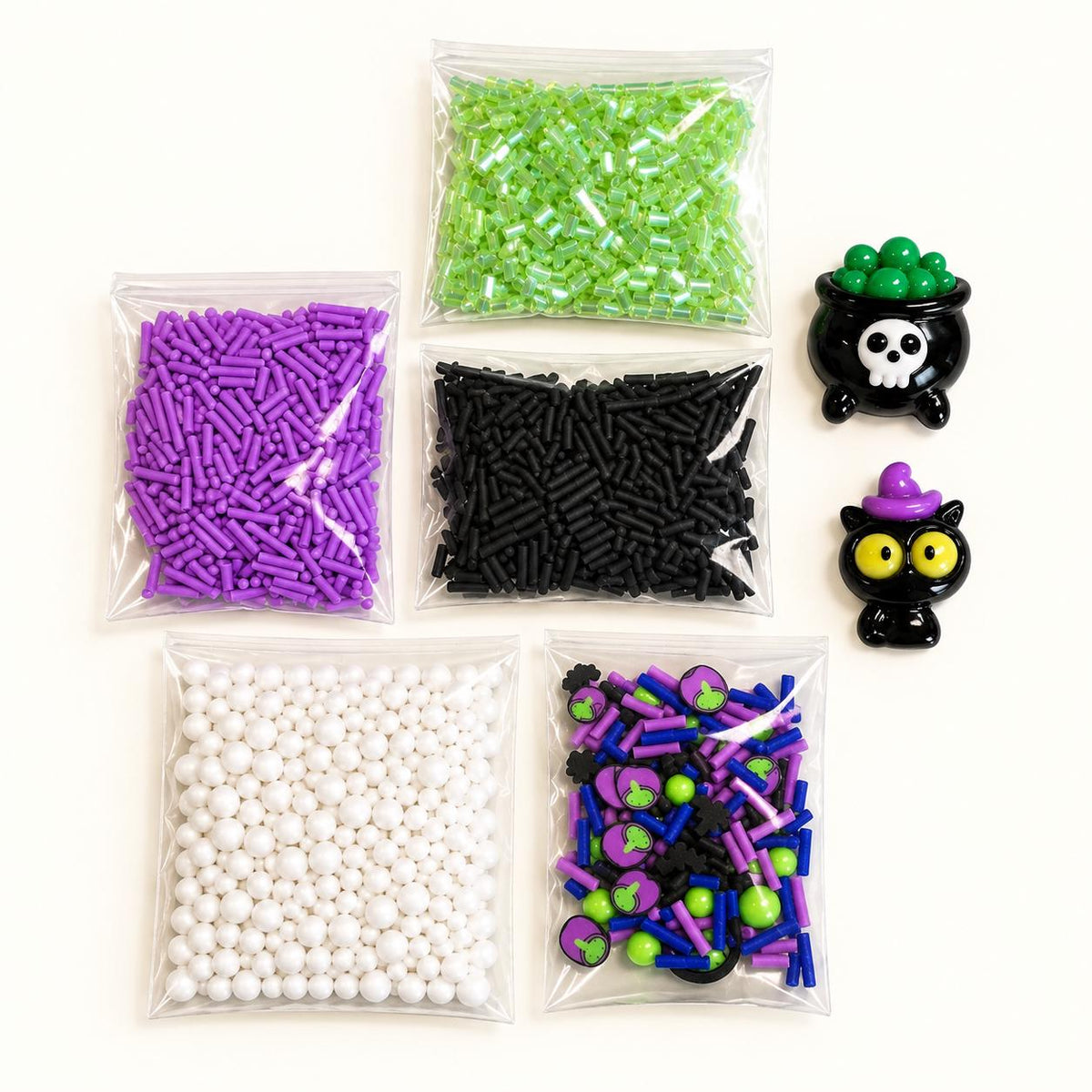 Halloween slime kit for kids featuring premade white slime, green slime dye, Halloween sprinkles, witch and black cat charms, apron and slime activator. Customizable DIY slime making kit for Halloween parties, spooky birthday parties, classroom celebrations, playdates, party favors, sensory activities and kids crafts. Fun Halloween activity for girls and boys, classroom party favor, birthday activity and creative sensory play kit