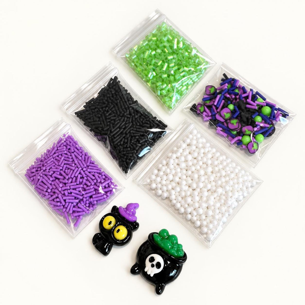 DIY Halloween slime making kit for kids with premade white slime, green slime coloring, spooky Halloween sprinkles, witch charm, black cat charm, apron and slime activator. Kids can customize their own slime for a fun Halloween party activity, classroom craft, spooky birthday activity, playdate or sensory play. Halloween kids activity kit makes a creative party favor, classroom activity, birthday favor or Halloween gift for children.