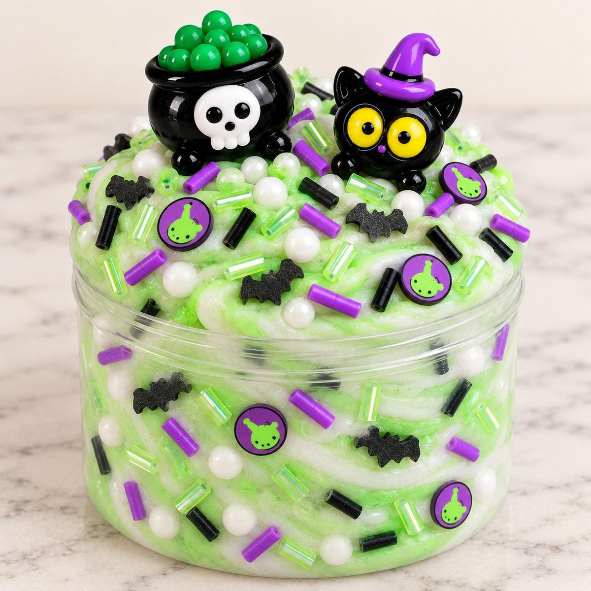 DIY Halloween slime making kit for kids with premade white slime, green slime coloring, spooky Halloween sprinkles, witch charm, black cat charm, apron and slime activator. Kids can customize their own slime for a fun Halloween party activity, classroom craft, spooky birthday activity, playdate or sensory play. Halloween kids activity kit makes a creative party favor, classroom activity, birthday favor or Halloween gift for children.