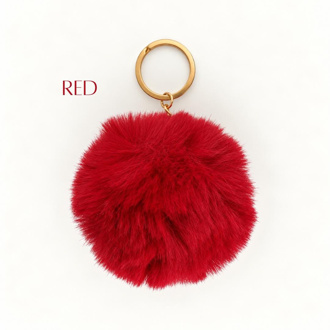 Fluffy pom pom keychain featuring a soft rounded faux fur-style pom pom with gold-tone metal key ring. Available in assorted colorful shades for decorating purses, handbags, backpacks, school bags, tote bags and keys. Cute gift for women and teens, Christmas stocking stuffer, birthday party favor, teacher appreciation gift, friendship gift and everyday fashion accessory.